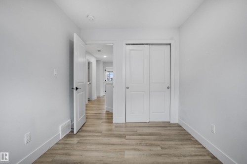Room featuring wood-finish flooring, white baseboards, and light gray walls - 1915 164 Street, Edmonton, AB 