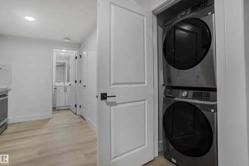Integrated laundry closet featuring a stacked washer and dryer unit - 1915 164 Street, Edmonton, AB 