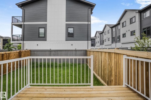 Ground-level deck featuring light-toned wood planks and white balusters - 1915 164 Street, Edmonton, AB 
