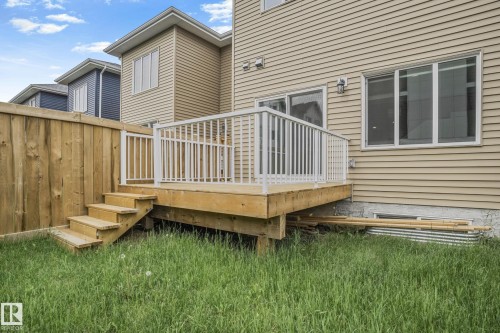 Rear wood deck featuring white railings, wood steps, and a privacy fence - 1915 164 Street, Edmonton, AB 