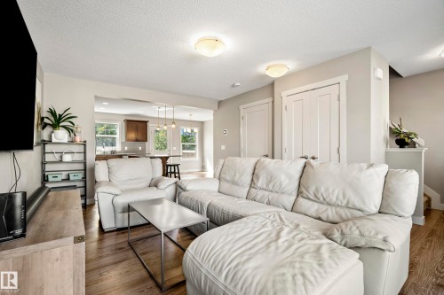 Open-concept living space featuring wood-finish flooring and recessed lighting - 11 4205 30 Street, Edmonton, AB 