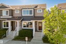 Townhome exterior featuring multi-toned siding, white trim, and a brown front door with glass insert - 11 4205 30 Street, Edmonton, AB 