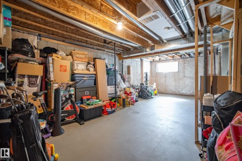 Unfinished basement space featuring exposed wood joists, concrete foundation walls, and a concrete floor - 11 4205 30 Street, Edmonton, AB 