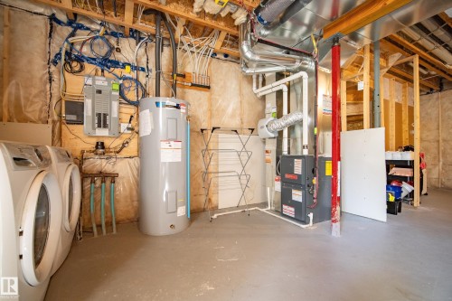 Utility room featuring a water heater, furnace, and exposed framing - 11 4205 30 Street, Edmonton, AB 