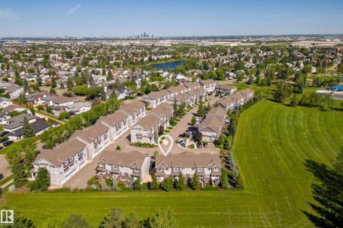 Aerial perspective of a multi-unit residential complex with multiple buildings featuring brown shingle roofs - 11 4205 30 Street, Edmonton, AB 