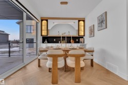 Dining area featuring wood-finish herringbone flooring and a built-in display niche with accent lighting - 