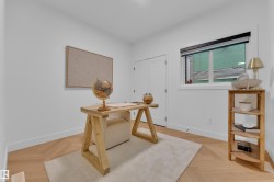 Light wood-finish flooring in a herringbone pattern featuring a neutral area rug - 