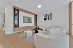 Integrated media wall with dark-framed display cabinetry and light wood-finish storage, paired with herringbone wood-finish flooring - 