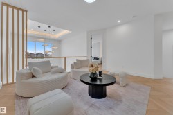 Bright upper-level bonus room featuring wood-finish herringbone flooring, a minimalist wood slat partition, and a glass railing - 