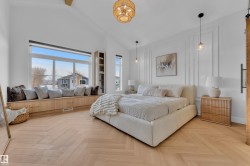 Spacious room featuring vaulted ceilings, herringbone wood-finish flooring, and a wide window bench with integrated storage - 