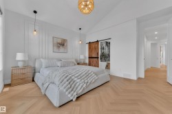 Spacious room with a vaulted ceiling and herringbone wood-finish flooring - 