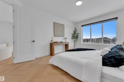Bright room featuring light wood-finish herringbone flooring and a large window - 