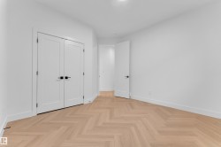Herringbone wood-finish flooring complements crisp white walls - 