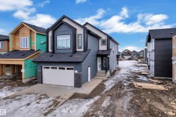 Modern two-story residence featuring a dark gray and off-white exterior with black trim accents - 