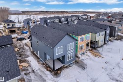 Modern residential development featuring multi-story properties with dark shingle roofs - 