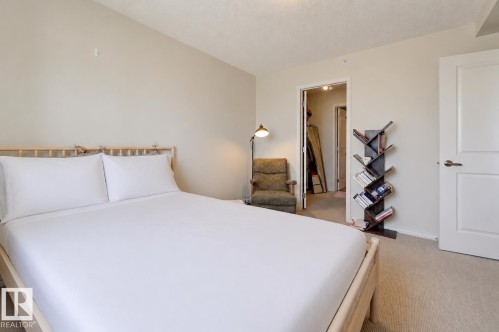 Bedroom featuring neutral wall paint, light-toned carpet, and a wooden bed frame - 1103 10180 104 Street, Edmonton, AB 