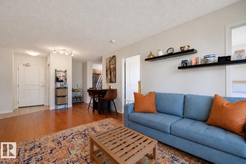 Open concept living area featuring wood-finish flooring, track lighting, and white walls - 1103 10180 104 Street, Edmonton, AB 