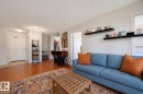 Open concept living area featuring wood-finish flooring, track lighting, and white walls - 1103 10180 104 Street, Edmonton, AB 