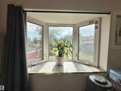 Bay window featuring a tiled sill, white window frames, and a black curtain rod - 11941 78 Street, Edmonton, AB 