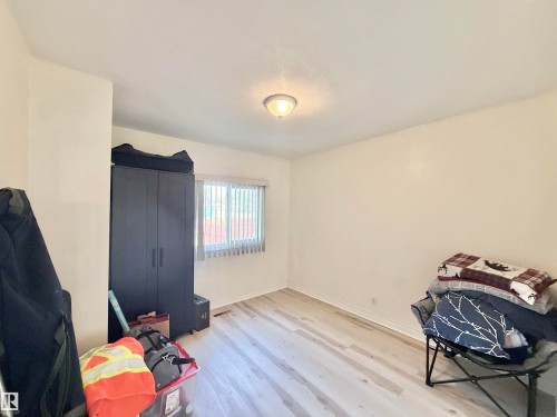 Room with light wood-finish flooring, white baseboards, and neutral wall tones - 11941 78 Street, Edmonton, AB 