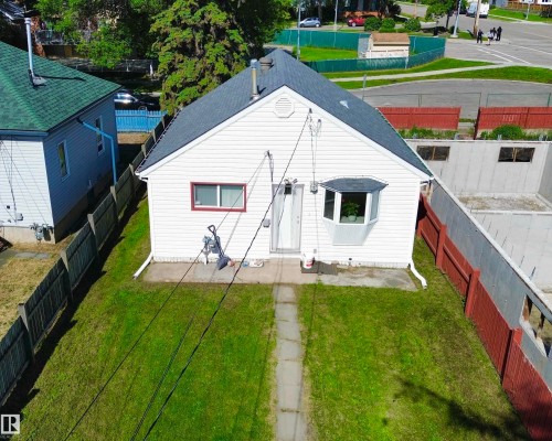 White siding residence featuring a dark shingled roof and a bay window - 11941 78 Street, Edmonton, AB 