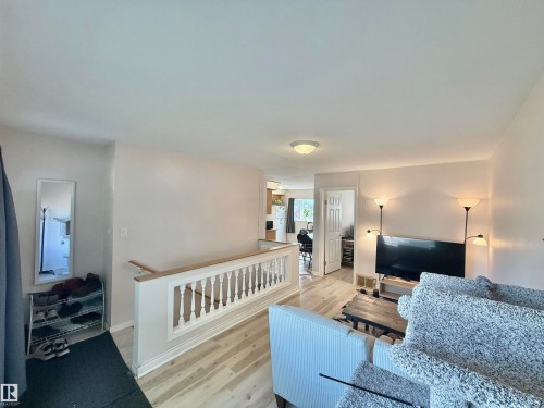 Light wood-finish flooring complements the neutral wall tones - 11941 78 Street, Edmonton, AB 