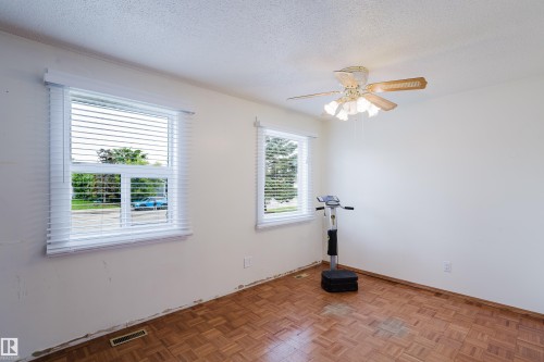 Room with two windows, a ceiling fan with light fixture, and parquet wood-finish flooring - 212 Homestead Crescent, Edmonton, AB 