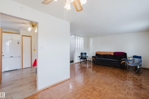 Living area featuring parquet wood-finish flooring, white walls, and a ceiling fan with light fixture - 212 Homestead Crescent, Edmonton, AB 