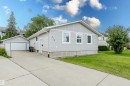 Light gray siding exterior with white trim windows and a concrete driveway - 212 Homestead Crescent, Edmonton, AB 