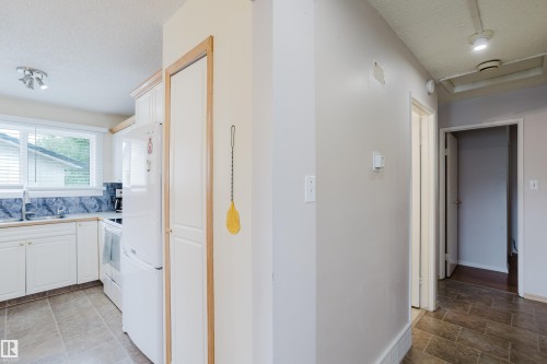 Kitchen featuring white cabinetry, a white refrigerator, and a white oven range - 212 Homestead Crescent, Edmonton, AB 