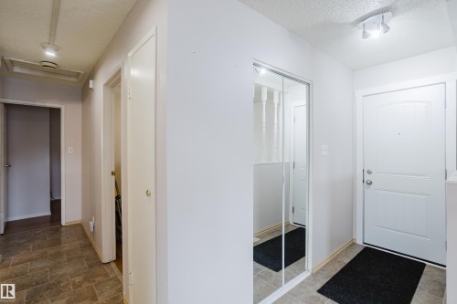 Entryway featuring a white paneled door, mirrored closet doors, recessed lighting, and tile flooring - 212 Homestead Crescent, Edmonton, AB 