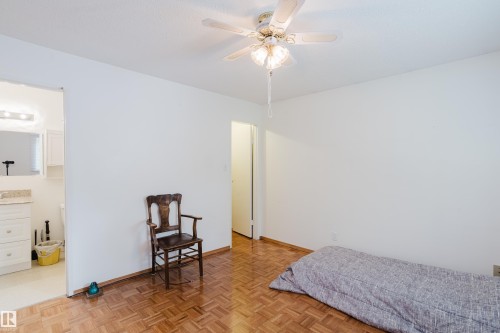 Parquet wood-finish flooring extends throughout this room, featuring a ceiling fan with integrated lighting - 212 Homestead Crescent, Edmonton, AB 