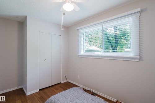 Interior room featuring wood-finish flooring, a white bi-fold closet, and a ceiling fan with integrated lighting - 212 Homestead Crescent, Edmonton, AB 