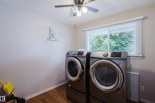 Laundry area featuring wood-finish flooring, a window with blinds, and an overhead ceiling fan with lighting - 212 Homestead Crescent, Edmonton, AB 