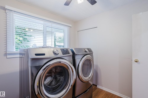 Dedicated utility space featuring wood-finish flooring, a window with horizontal blinds, and a ceiling fan - 212 Homestead Crescent, Edmonton, AB 