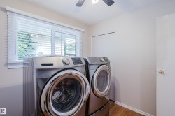 Dedicated utility space featuring wood-finish flooring, a window with horizontal blinds, and a ceiling fan - 
