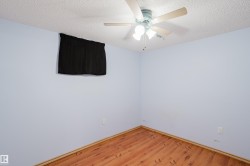 Room featuring wood-finish flooring, light blue walls, and a textured white ceiling - 