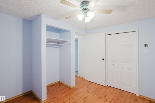 Room featuring wood-finish flooring, light blue walls, and a textured white ceiling - 212 Homestead Crescent, Edmonton, AB 
