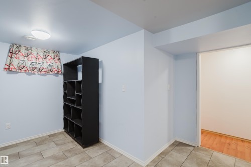 Room featuring tile flooring, a flush-mount ceiling light, and a window with valance - 212 Homestead Crescent, Edmonton, AB 