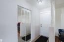 Entryway featuring a white paneled door, track lighting, and a partial baluster wall - 212 Homestead Crescent, Edmonton, AB 