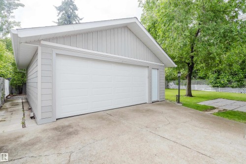 Detached two-car garage with light gray siding, white trim, and a white panel garage door - 212 Homestead Crescent, Edmonton, AB 