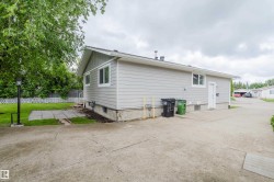 Gray siding exterior with white trim windows and a side entrance - 
