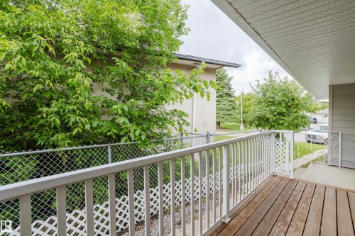 Wood-finish porch decking with white railing and lattice detailing - 212 Homestead Crescent, Edmonton, AB 