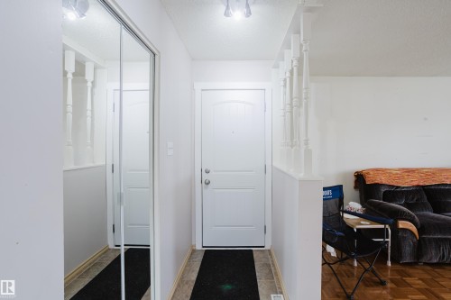Entryway featuring light-toned flooring, a paneled entry door, and track lighting - 212 Homestead Crescent, Edmonton, AB 