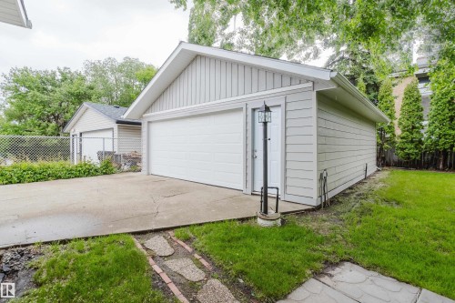 Detached garage with a single overhead door and a side entry door featuring a lamppost - 212 Homestead Crescent, Edmonton, AB 