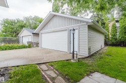 Detached garage with a single overhead door and a side entry door featuring a lamppost - 