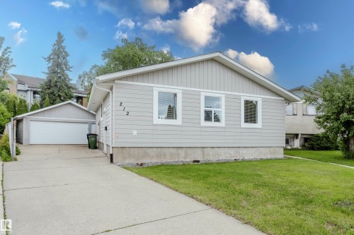 Light gray siding exterior with white window trim and a detached garage - 212 Homestead Crescent, Edmonton, AB 