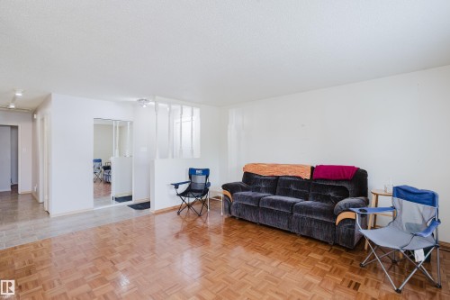 Parquet wood-finish flooring extending into a bright living area with white walls - 212 Homestead Crescent, Edmonton, AB 