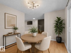 Open-concept dining area featuring wood-finish flooring, a contemporary ceiling light fixture, neutral wall finishes, and a sliding glass door - 