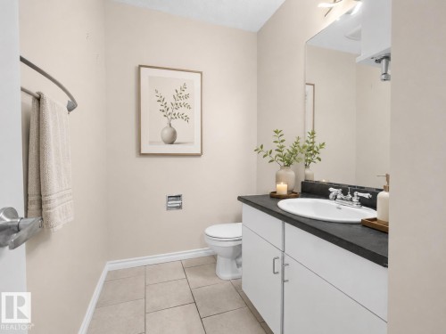 Bathroom featuring a white vanity with a dark countertop, an integrated sink, and chrome fixtures - 1855 Mill Woods Rd E Nw, Edmonton, AB 